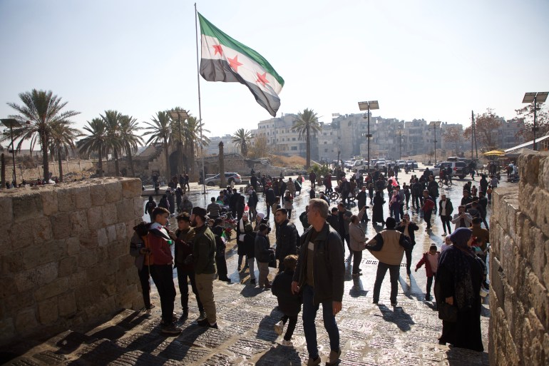 Bendera Suriah berkibar di dekat benteng bersejarah Aleppo (Ali Haj Suleiman/Al Jazeera)